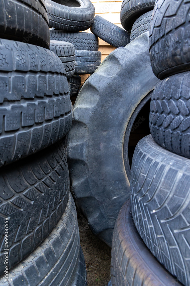 Stack of old, worn and damaged tires lying in a landfill. Decreased road safety and environmental pollution from rubber waste Stack of old, worn and damaged tires lying in a landfill. Decreased road safety and environmental pollution from rubber waste