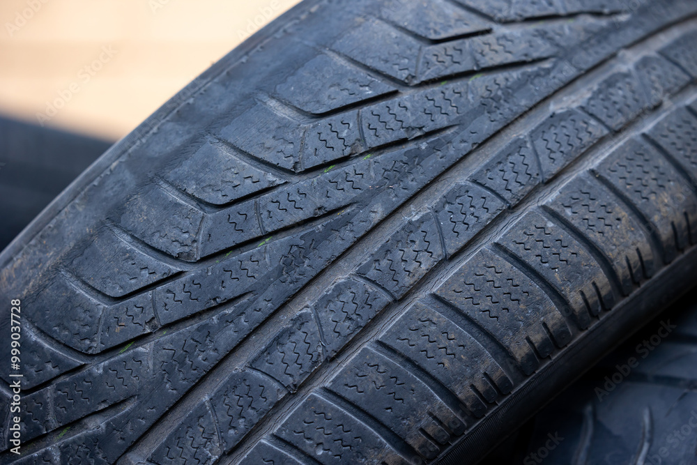 Worn and damaged tread of old tires lying in a landfill. Decreased road safety and environmental pollution from rubber waste