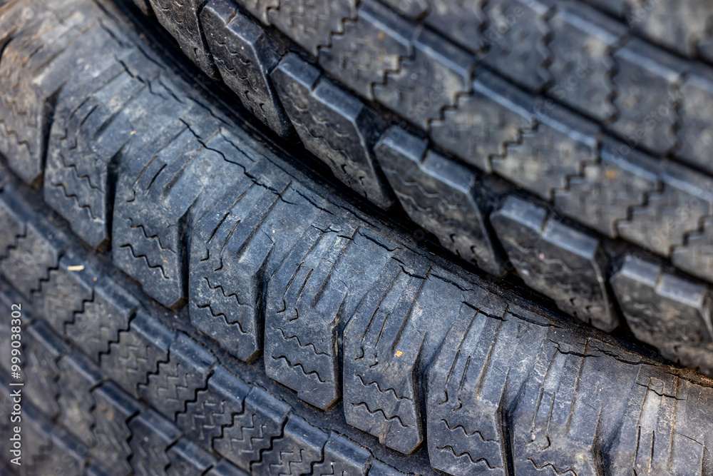 Worn and damaged tread of old tires lying in a landfill. Decreased road safety and environmental pollution from rubber waste
