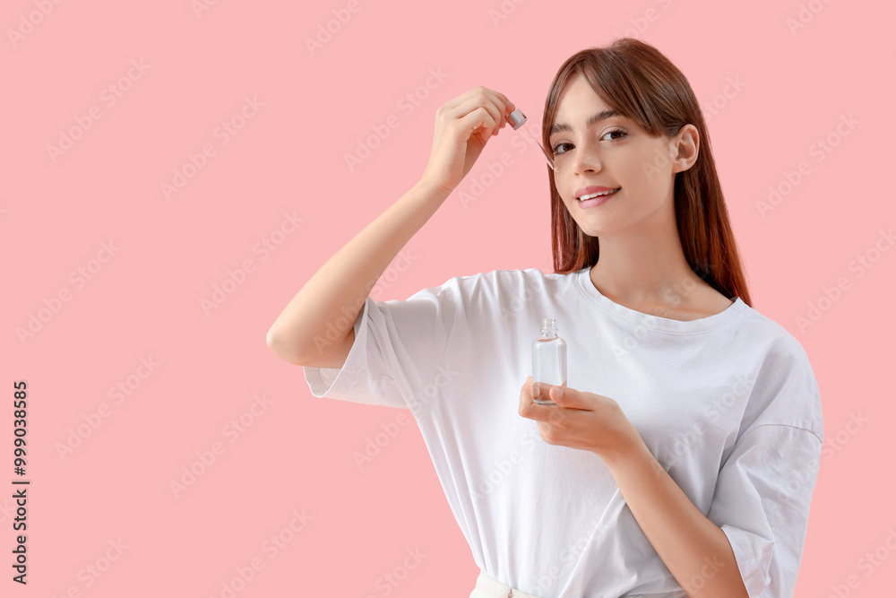 Beautiful young woman applying serum on pink background Beautiful young woman applying serum on pink background