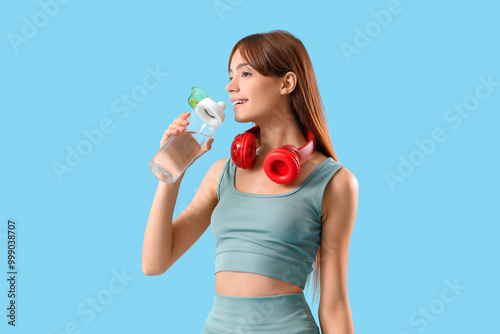 Sporty young woman drinking...