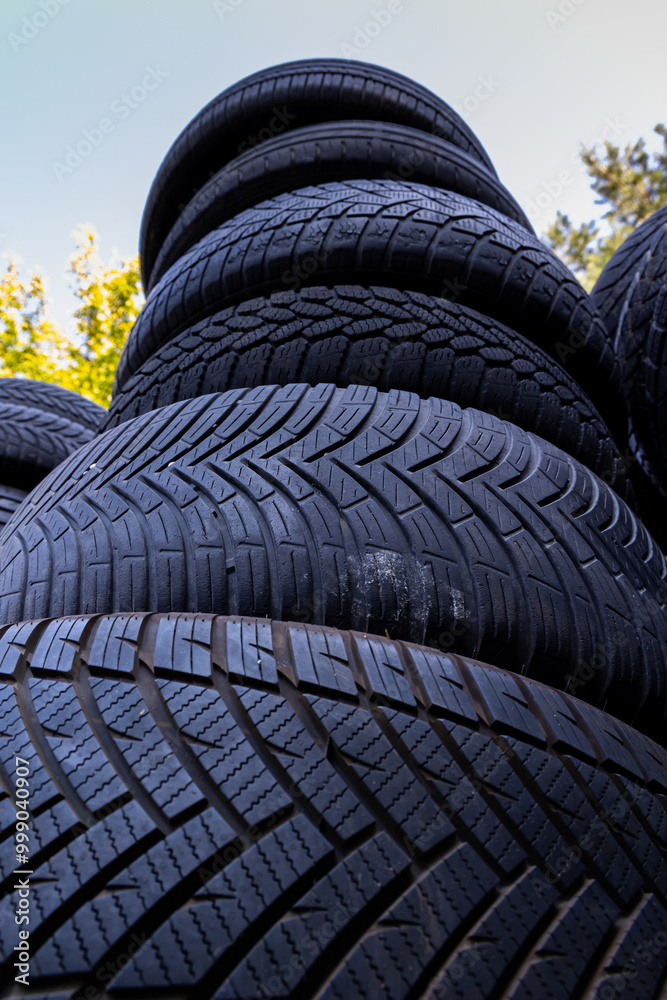 Stack of old, worn and damaged tires lying in a landfill. Decreased road safety and environmental pollution from rubber waste