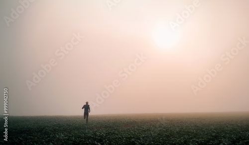 Silhouette of young runner in soft autumn fog