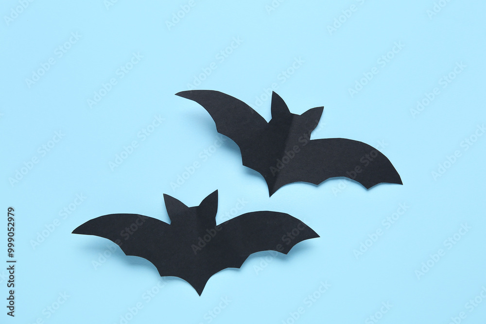 Black paper bats for Halloween party on blue background Black paper bats for Halloween party on blue background