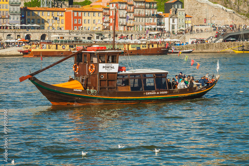 A scenic view of the Douro River in Porto, Portugal, featuring traditional Rabelo boats used historically for transporting wine barrels photo