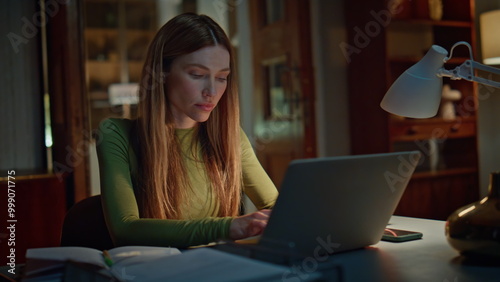 Tired manager working night home looking laptop close up. Woman writing copybook photo