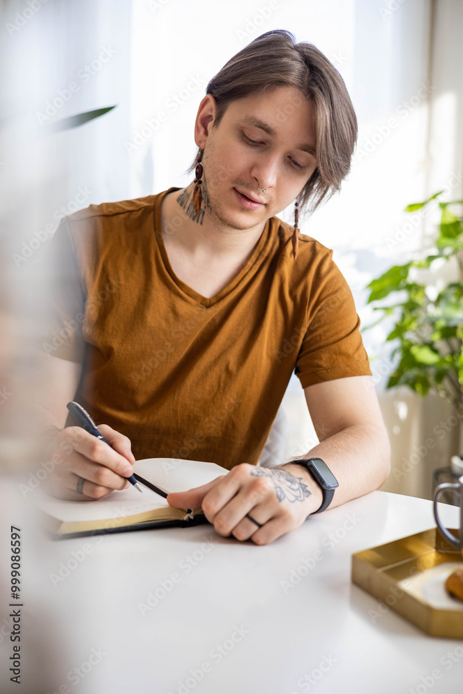 Stylish confident guy writing in journal Stylish confident guy writing in journal