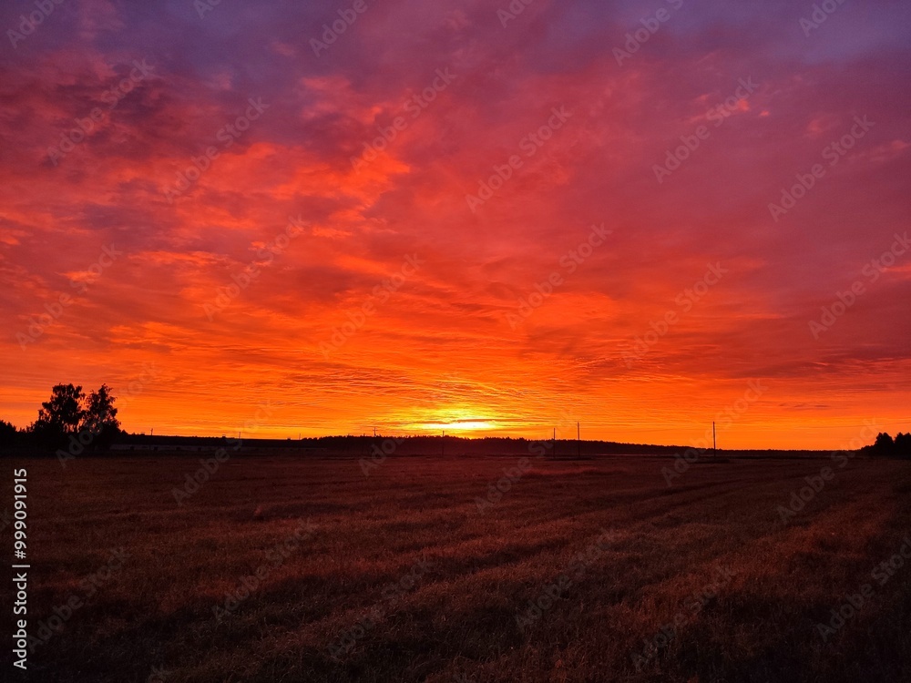 beautiful, bright, red, sunset on a late autumn evening against the backdrop of a mown field in the village and scarlet clouds beautiful, bright, red, sunset on a late autumn evening against the backdrop of a mown field in the village and scarlet clouds