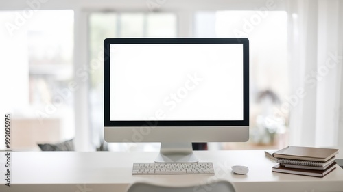 Modern desktop computer on a minimalistic white desk with notebooks, in a bright home office setting.