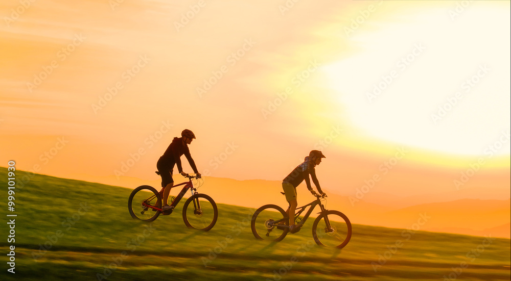 AERIAL: Golden evening sunbeams shine on mountain bikers speeding down a grassy hill in the beautiful Slovenian mountains. Scenic drone view of active people riding e-bikes in the scenic Dolomites. AERIAL: Golden evening sunbeams shine on mountain bikers speeding down a grassy hill in the beautiful Slovenian mountains. Scenic drone view of active people riding e-bikes in the scenic Dolomites.