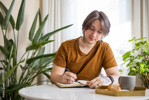 Stylish confident guy writing in journal