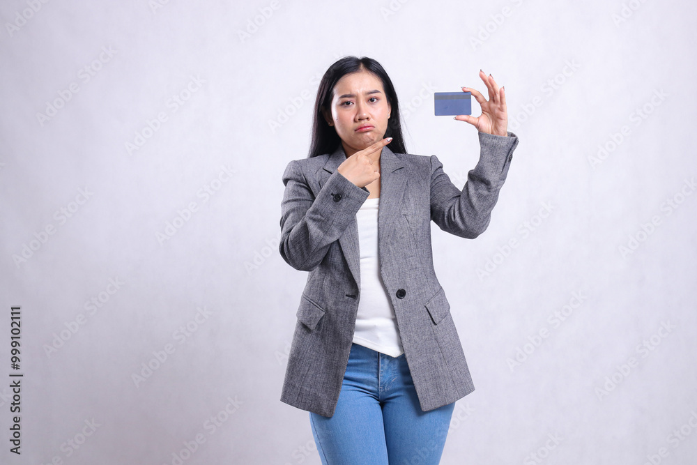 gesture young office girl asia sad pointing and holding debit credit card wearing grey suit standing isolated on white background. for advertising content, lifestyle, finance, transaction gesture young office girl asia sad pointing and holding debit credit card wearing grey suit standing isolated on white background. for advertising content, lifestyle, finance, transaction