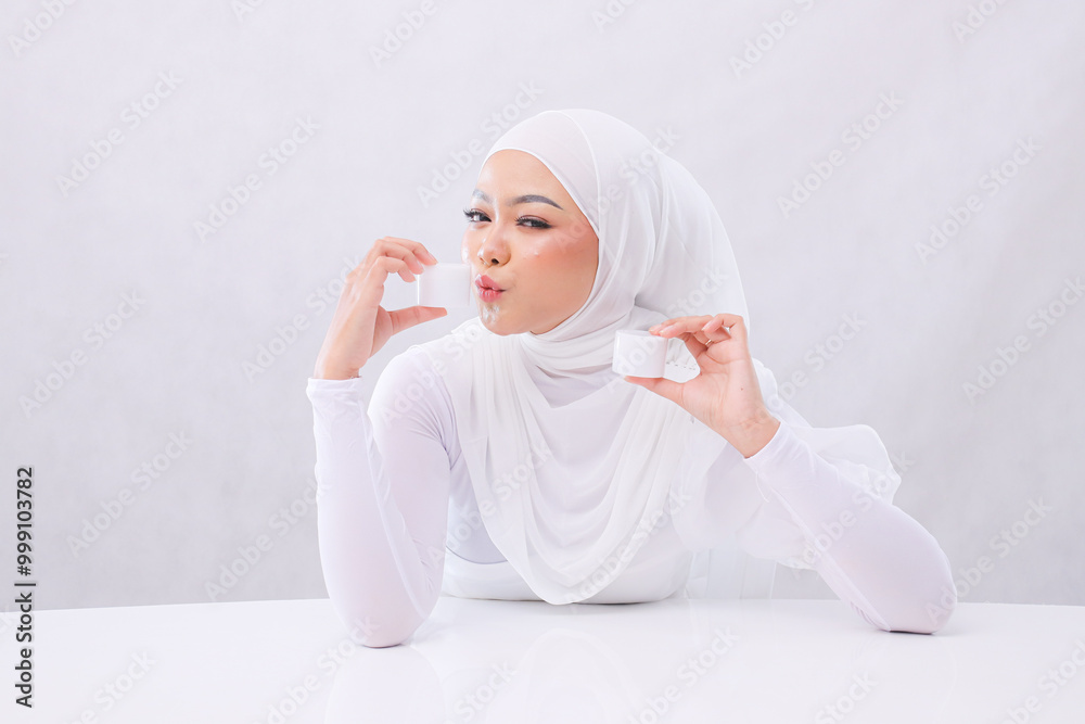 Gesture Beautiful adult woman veil smell cream look at camera both hands hold cosmetic cream in front of head to show skin care products on white background. Commercial, health, medical concept Gesture Beautiful adult woman veil smell cream look at camera both hands hold cosmetic cream in front of head to show skin care products on white background. Commercial, health, medical concept