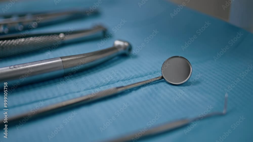 Closeup dental mirror taken by unknown dentist in stomatology. Sterilized tools Closeup dental mirror taken by unknown dentist in stomatology. Sterilized tools