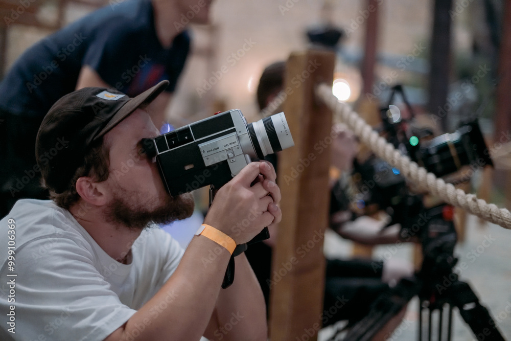 Director of photography with a camera in his hands on the set. Professional videographer at work on filming a movie Director of photography with a camera in his hands on the set. Professional videographer at work on filming a movie
