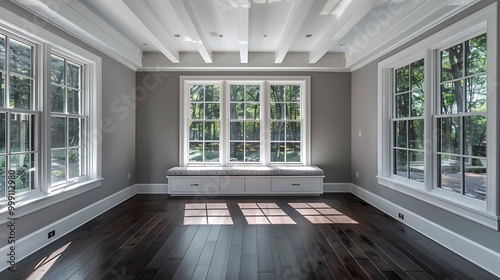 White windows, gray walls, dark wood floors, window seat, beamed white ceiling, large sunroom, home decor style.