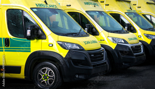Ambulances - emergency services ambulance vehicles on standby.  The medically equipped transport moves patients with paramedics from scene to a health care facility, such as a hospital, for treatment. photo
