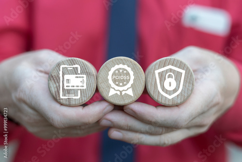 Business man holding wooden blocks with icons symbolizing concept: PCI DSS. PCI DSS - Payment Card Industry Data Security Standard Concept. IT Security. photo