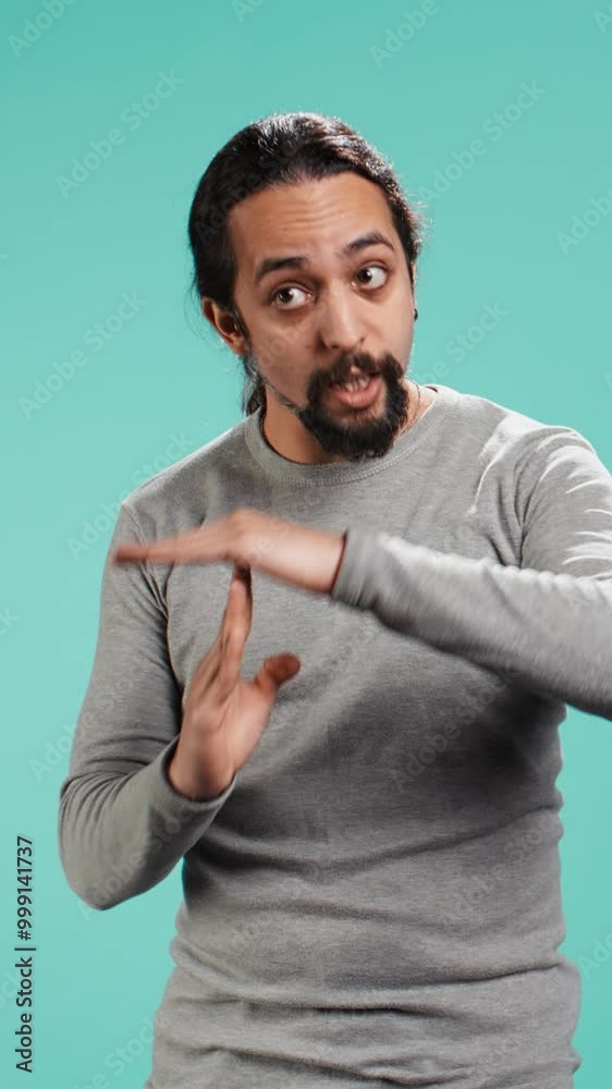 Vertical video Portrait of assertive man asking for timeout, doing hand gestures, feeling fatigued. Unhappy person doing vehement pause sign gesturing, wishing for break, studio background, camera B Vertical video Portrait of assertive man asking for timeout, doing hand gestures, feeling fatigued. Unhappy person doing vehement pause sign gesturing, wishing for break, studio background, camera B