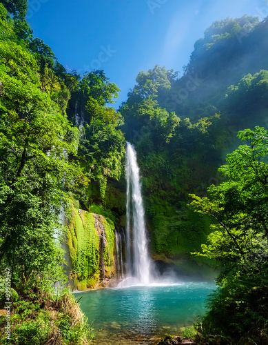 A breathtaking waterfall cascades through lush greenery, creating a vibrant pool of turquoise wate