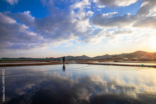 Muan-gun, Jeollanam-do, South Korea - March 14, 2020: A male worker is salting in a salt farm in the moring