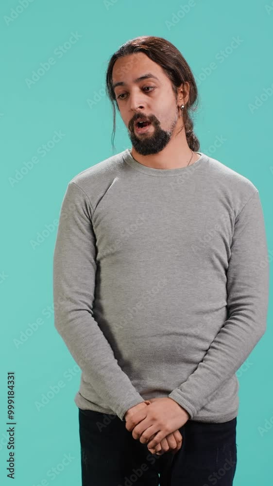 Vertical video Portrait of bored man lacking enthusiasm to do anything, yawning, wasting time, isolated over studio background. Lazy person living monotonous life, having sleepy dull facial expression