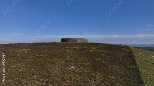 Grianan of Aileach, County Donegal, Ireland, June 2023. Drone aerial ascent atop a hill overlooking the Gaelic Greenan Stone Fort surrounded by scenic countryside on a sunny afternoon. photo