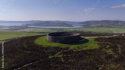 Grianan of Aileach, County Donegal, Ireland, June 2023. Drone pulls backward ascending to reveal the iconic Gaelic Ringfort and view north with Inch Wildfowl Reserve and Lough Swilly in the distance. photo