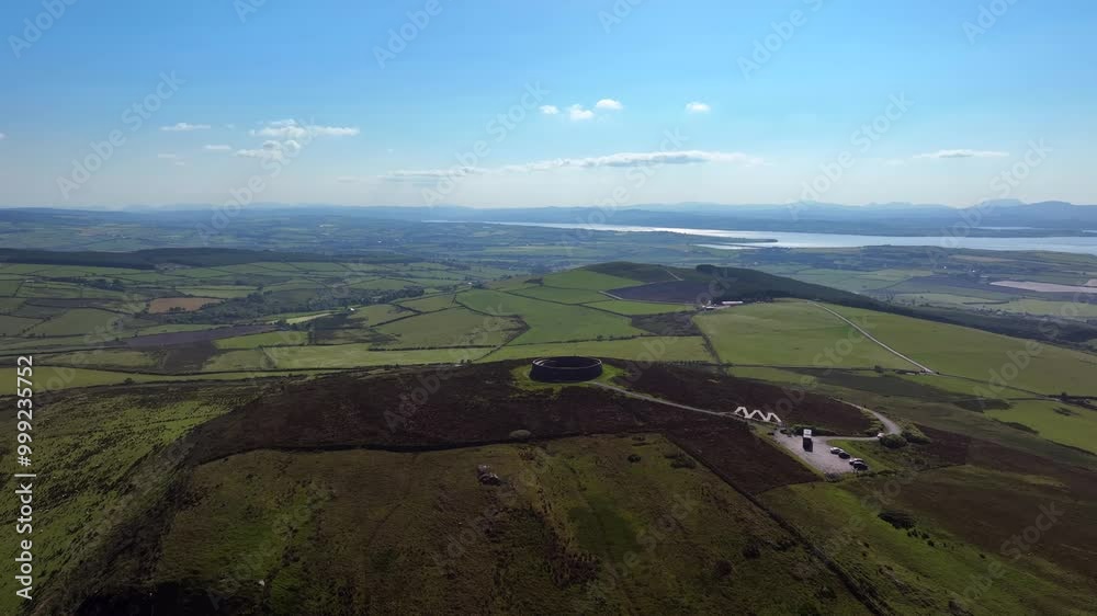 Grianan of Aileach, County Donegal, Ireland, June 2023. Drone wide angle counter clockwise orbit above the iconic Gaelic Ringfort surrounded by green fields with Drongawn Lough in the background. Grianan of Aileach, County Donegal, Ireland, June 2023. Drone wide angle counter clockwise orbit above the iconic Gaelic Ringfort surrounded by green fields with Drongawn Lough in the background.