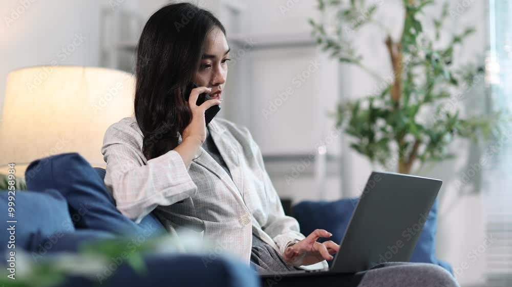 Businesswoman working at home is multitasking, using a laptop computer and smartphone. Businesswoman working at home is multitasking, using a laptop computer and smartphone.