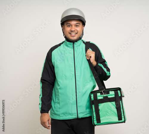 Young asian rider wearing green jacket uniform and helmet various action holding a lot of paper parcel delivery box to customer. Man service worker Courier and shipping food delivery service. photo