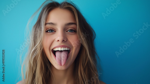 Portrait of a young woman sticking her tongue out isolated on blue background. Space for text. Human emotions, reactions, feelings and attitude. Generative AI. 