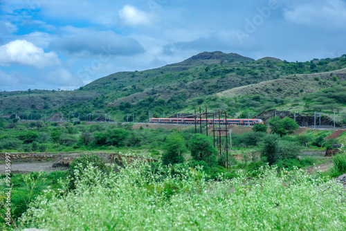 Saffron coloured Vande Bharat Express near Pune India. This is a tri-weekly train between Pune and Kolhapur and also a tri-weekly train between Pune and Hubballi. photo