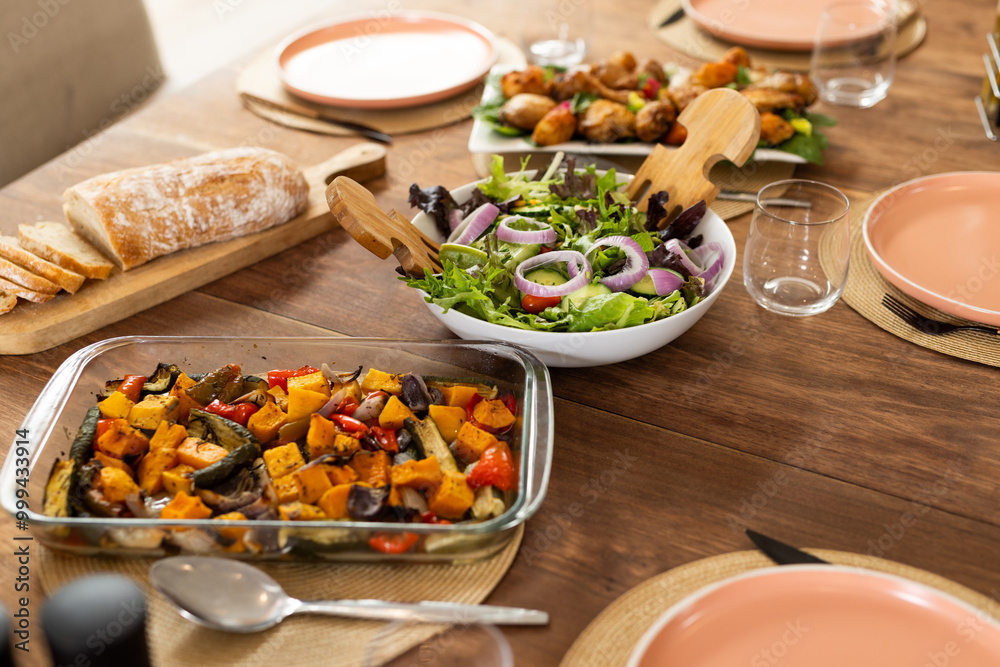 Serving fresh salad and roasted vegetables on dining table for diverse friends gathering, at home Serving fresh salad and roasted vegetables on dining table for diverse friends gathering, at home