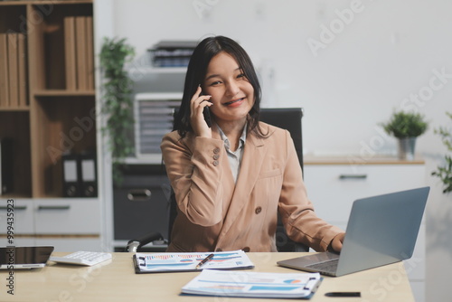 Asian businesswoman in formal suit in office happy and cheerful during using smartphone and working