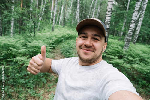 Man smiling and taking a selfie in the forest