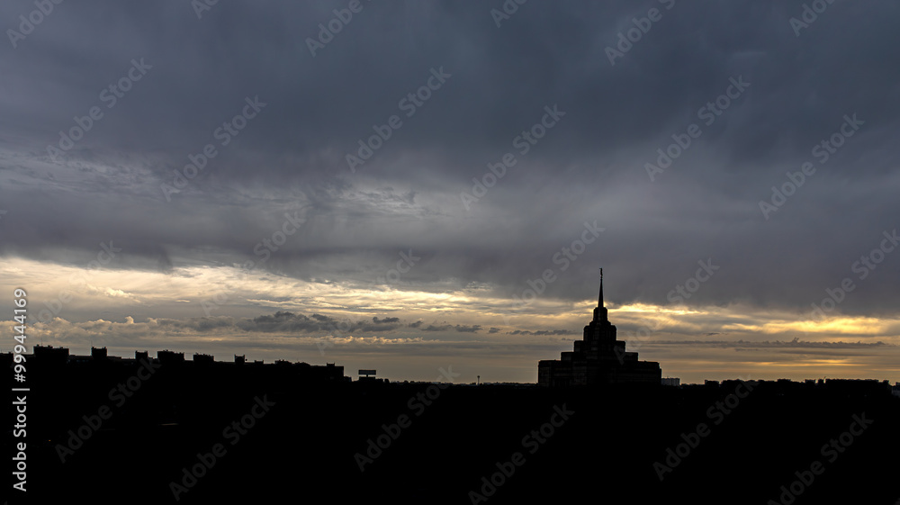 Silhouette of the evening city and the church on the background of the cloudy sky. Dramatic sunset sky. City view. Panorama of a big city. Blackout in Ukraine. Power outage. City in darkness. Silhouette of the evening city and the church on the background of the cloudy sky. Dramatic sunset sky. City view. Panorama of a big city. Blackout in Ukraine. Power outage. City in darkness.