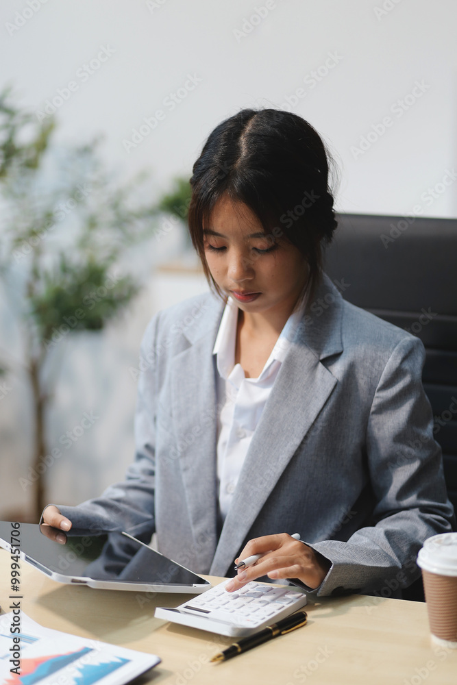 Successful Asian businesswoman smiling using laptop computer and holding coffee cup at office. Confident Asia businesswoman sitting happily in the office. Successful Asian businesswoman smiling using laptop computer and holding coffee cup at office. Confident Asia businesswoman sitting happily in the office.
