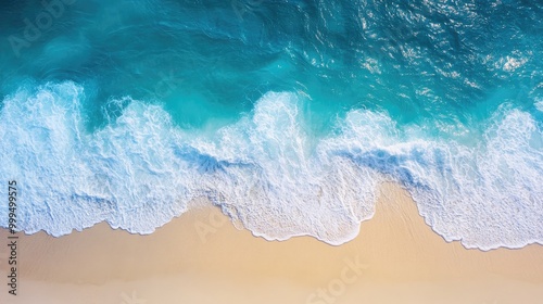 Aerial perspective of a tropical beach showcasing soft waves lapping the shore where the sea meets the coastline featuring shades of blue and a pristine sandy expanse under sunlight