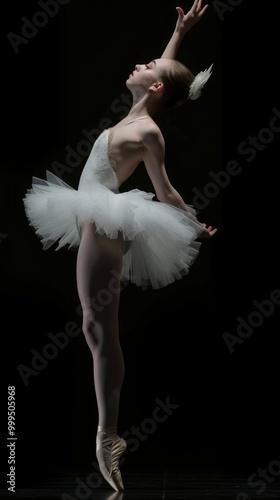 A ballerina in a white tutu, standing on pointe, with her arm extended gracefully, performing a ballet pose on a dark background.