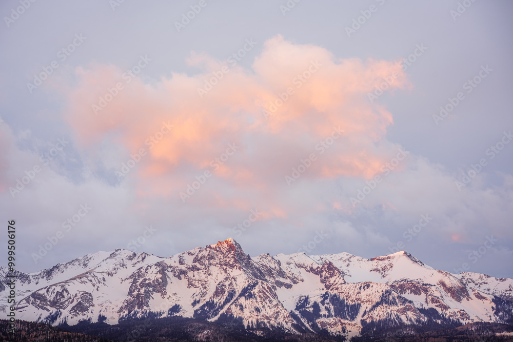 sunrise light on a snowy mountain peak with dramatic clouds sunrise light on a snowy mountain peak with dramatic clouds