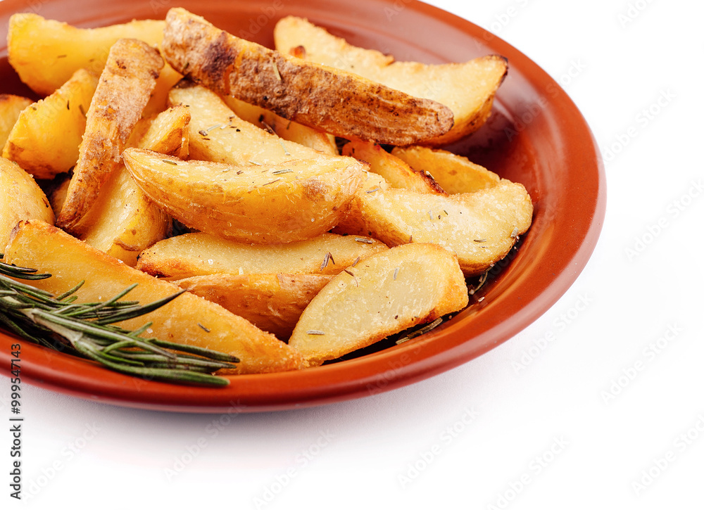 Delicious baked potato wedges with rosemary lying on a plate Delicious baked potato wedges with rosemary lying on a plate