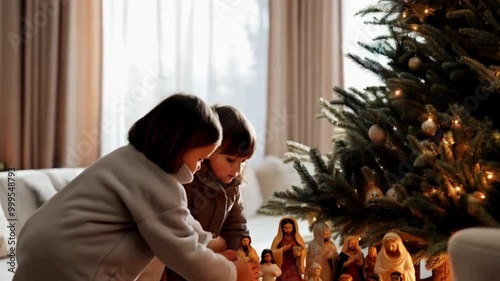 Children Setting Up a Nativity Scene Kids carefully arranging a nativity scene under the Christmas tree.