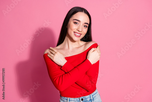 Portrait of pretty young girl arms touch shoulders red top isolated on pink color background