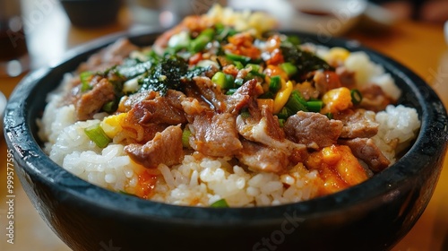 A bowl of rice topped with meat and vegetables. A close up of a delicious and colorful Korean dish of bibimbap.