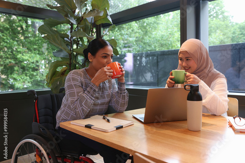 Coworkers drinking coffee in modern office