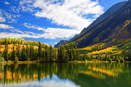 beautiful golden aspen trees reflected in dollar lake  in fall along the three lakes loop hiking trail via lost lake in the  rocky mountains along kebler pass near crested butte, colorado photo