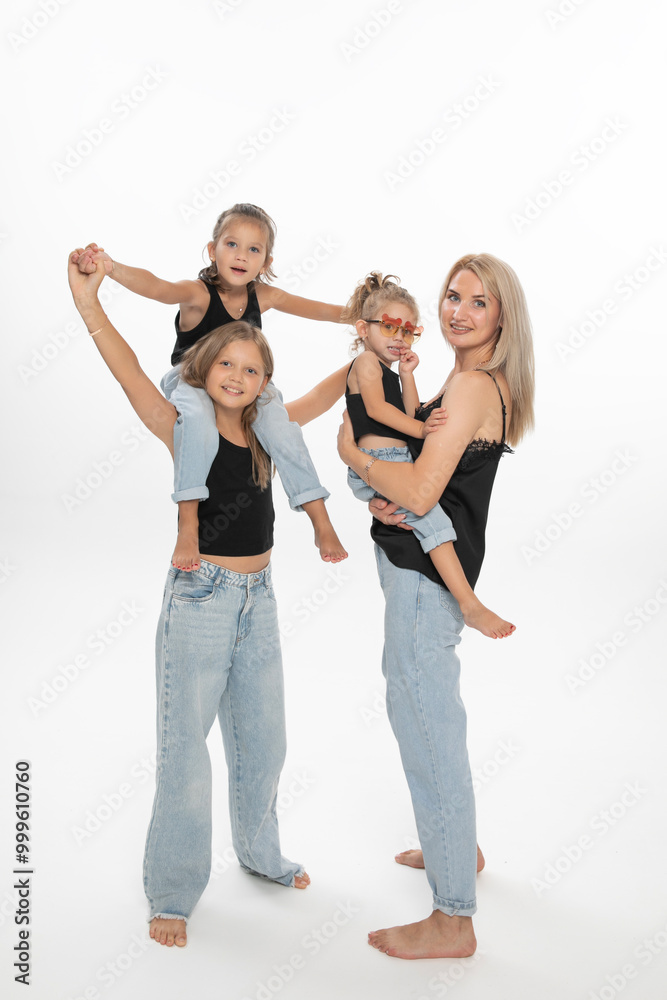 Happy fashionable modern family concept. Young mom with her daughters, posing in studio. Enjoy time together. Copy space. Happy fashionable modern family concept. Young mom with her daughters, posing in studio. Enjoy time together. Copy space.