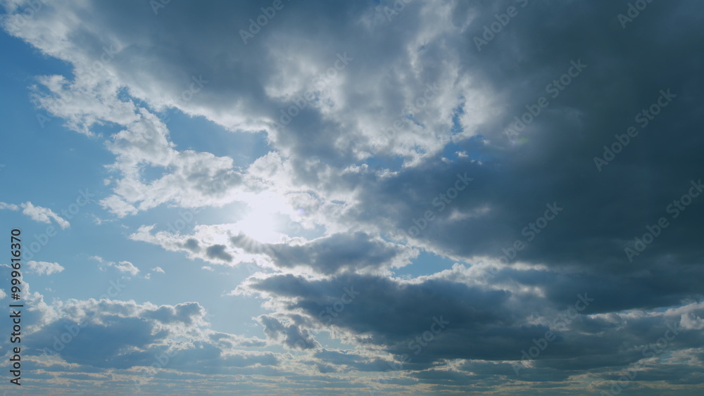 Obraz premium Beautiful cloudscape with large, building clouds. Suns rays shine through the cloud. Timelapse.