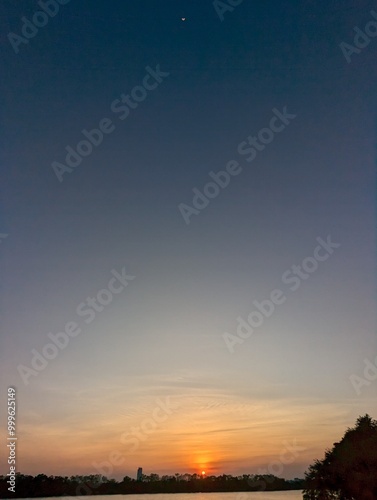 Moon and sun together above Bangkok winter sky